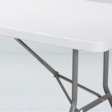 Folding banquet table detail showing durable white plastic top and sturdy steel legs for special events.